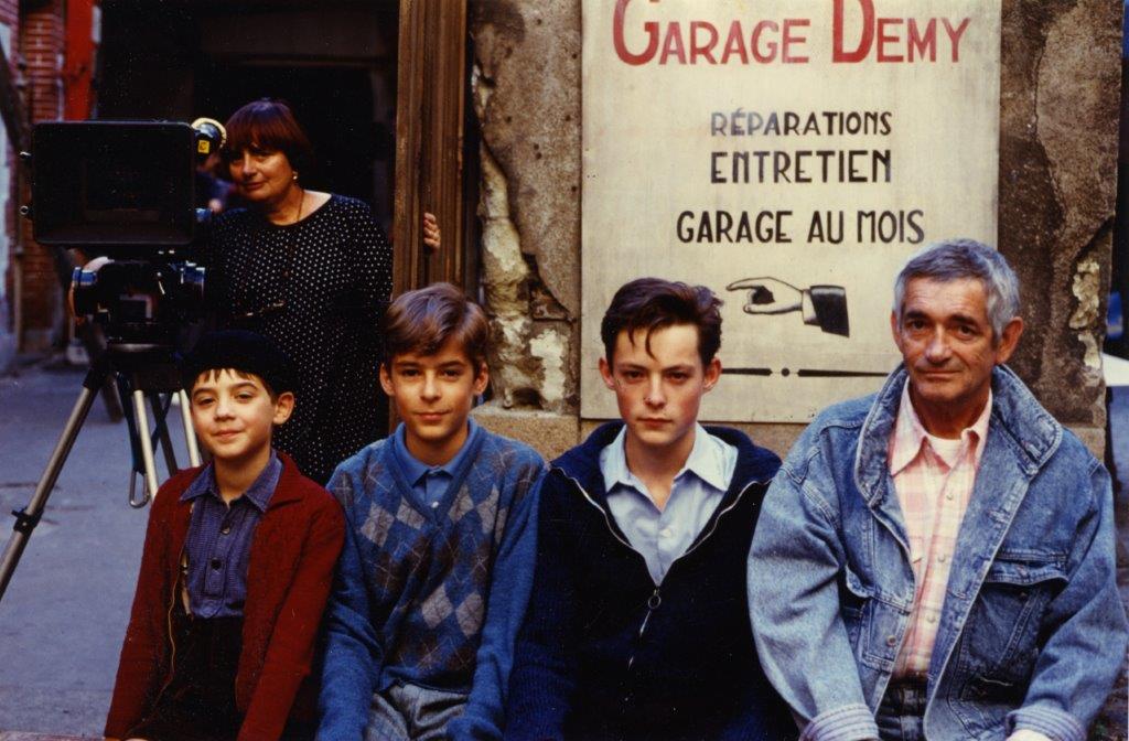Jacques Demy with the three boys who portray him as a child. Agnès Varda in the background.